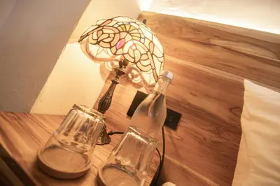 a table with a lamp and two glass bottles on it at Casa Be Getsemaní in Cartagena de Indias