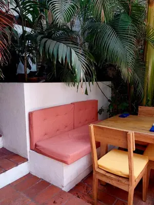 a red bench and a table and a table and chairs at Casa Be Getsemaní in Cartagena de Indias