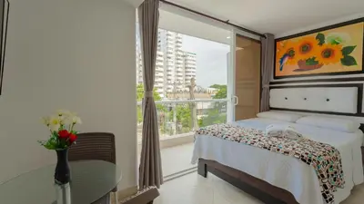 a bedroom with a bed and a large window at Hollywood Beach Suite in Cartagena de Indias