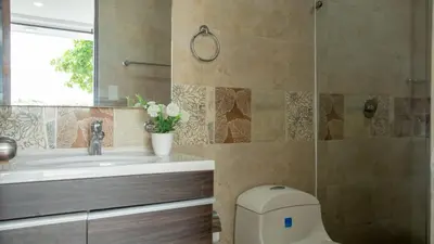 a bathroom with a toilet and a sink and a mirror at Hollywood Beach Suite in Cartagena de Indias