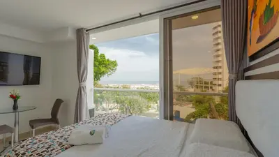 a bedroom with a bed and a view of the ocean at Hollywood Beach Suite in Cartagena de Indias