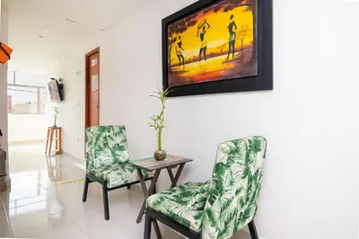 a living room with two chairs and a table and a painting at Hotel Masinda in Cartagena de Indias
