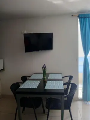 a dining room table with chairs and a television on a wall at Cartagena Linda 204 in Cartagena de Indias