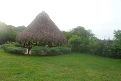 a grass roofed gazebo in a yard at Cabana Dubai Resorts in Santa Veronica