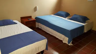 two beds in a room with blue and white at Hotel Sandiego inc in Barranquilla