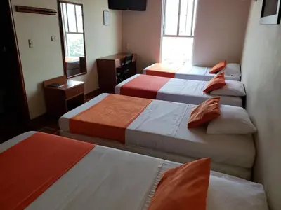 a hotel room with four beds in a room at Hotel Sandiego inc in Barranquilla