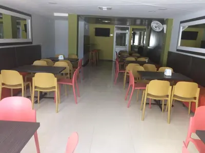 a row of tables and chairs in a restaurant at Hotel 56 Avenue Plaza in Barranquilla