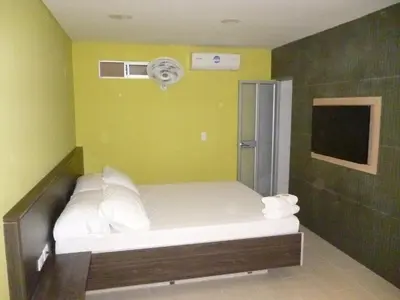 a small bed in a room with a fan at Hotel 56 Avenue Plaza in Barranquilla