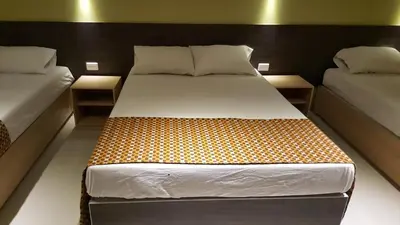 a bed in a room with two twin beds at Hotel 56 Avenue Plaza in Barranquilla