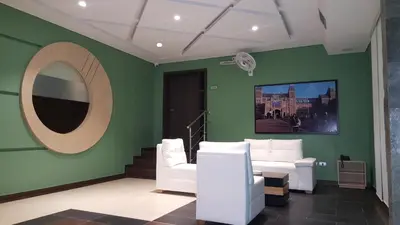 a green room with white chairs and a mirror at Hotel 56 Avenue Plaza in Barranquilla