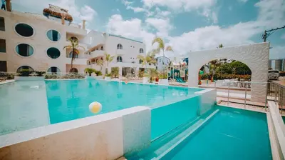 a swimming pool next to a large building at Loa Tolú by Bernalo Hotels in Tolú