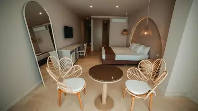 a room with a bed and a table and chairs at Loa Tolú by Bernalo Hotels in Tolú