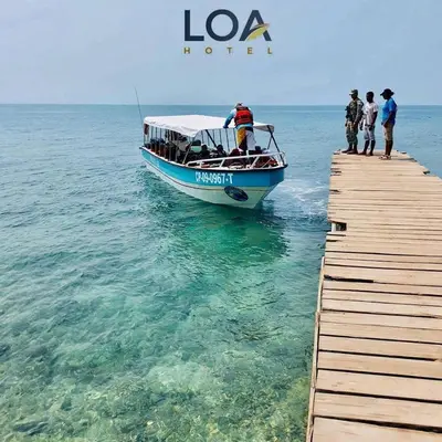 a boat on the water next to a pier at Loa Tolú by Bernalo Hotels in Tolú