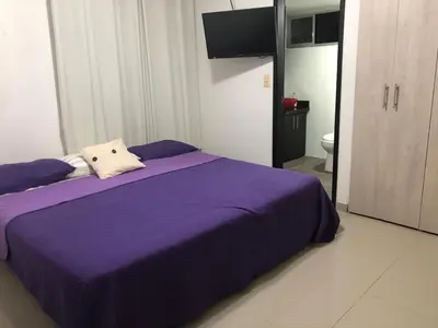 a bedroom with a purple bed and a television at Apartamento Playero in Cartagena de Indias
