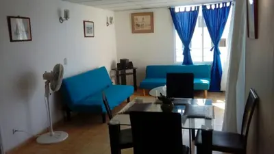 a living room with a blue couch and a table at Apartamento Playero in Cartagena de Indias