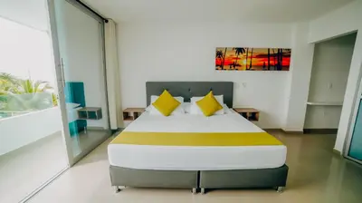 a bedroom with a large bed with yellow pillows at Green Coveñas by Bernalo Hotels in Coveñas