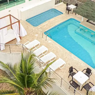 a pool with chairs and a table and a swimming pool at Green Coveñas by Bernalo Hotels in Coveñas