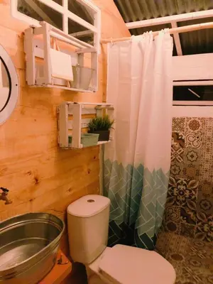 a bathroom with a toilet and a shower curtain at Pura Vida Baru - La Casa del Cholo in Baru