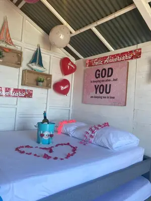 a bed in a room with a sign on the wall at Pura Vida Baru - La Casa del Cholo in Baru