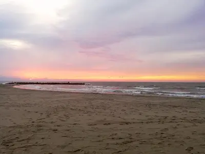 a sunset on the beach with a pier in the water at Apartamento Marbella #2-14 in Cartagena de Indias