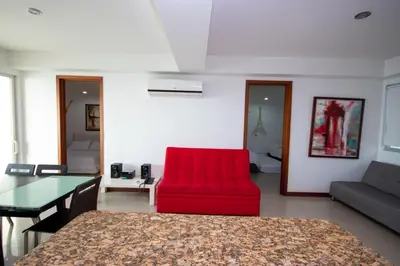 a living room with a red chair and a table at Excelente Apartamento Palmetto con vista al mar in Cartagena de Indias