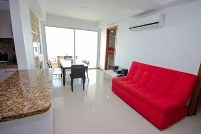 a red couch in a living room with a table at Excelente Apartamento Palmetto con vista al mar in Cartagena de Indias