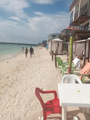 a beach with a table and chairs and the ocean at Cabaña Luna Azul in Playa Blanca
