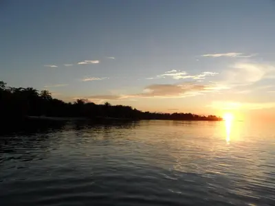 a sunset over a body of water with trees at Condominio Milagros Coveñas in Coveñas