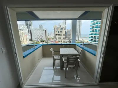 a balcony with a table and chairs and a view of the city at Apartamento Vista Lateral a la Playa By ICDI in Cartagena de Indias