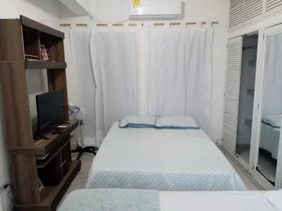 a small bedroom with two beds and a television at Alojamiento Arte y Salud in Cartagena de Indias