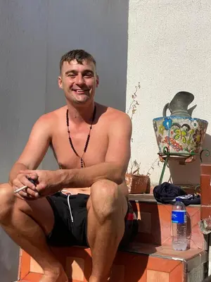 a shirtless man sitting on a table with his legs crossed at Alojamiento Arte y Salud in Cartagena de Indias