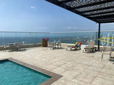 a patio with chairs and tables and a swimming pool at Apartamento Frenta a la Playa in Cartagena de Indias