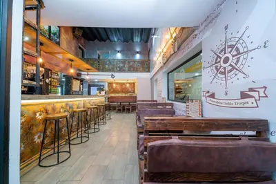 a bar with wooden tables and chairs in a restaurant at Hotel Baly Express in Malambo