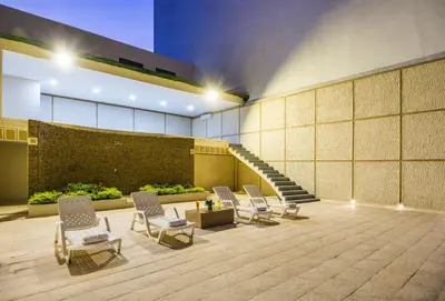 a lobby with chairs and stairs in a building at Ribai Hotels - Barranquilla in Barranquilla
