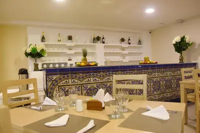 a dining room with a table with glasses and napkins at Ribai Hotels - Barranquilla in Barranquilla