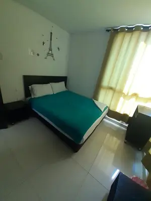 a bedroom with a green bed with a window at Hotel La Mar Cartagena in Cartagena de Indias