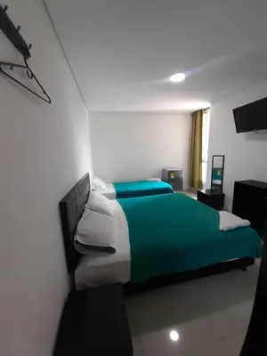 a bedroom with a green and white bed in a room at Hotel La Mar Cartagena in Cartagena de Indias