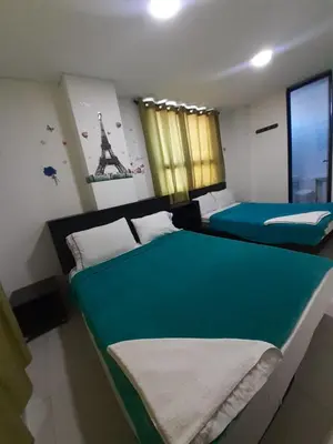 two beds in a room with a green and white at Hotel La Mar Cartagena in Cartagena de Indias