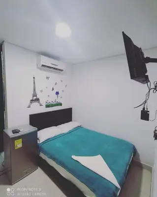a bedroom with a bed and a television and the eiffel tower at Hotel La Mar Cartagena in Cartagena de Indias