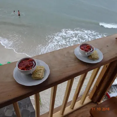 two bowls of food sitting on a table next to the beach at Hostel Blue Sea Rincon del Mar in Rincón