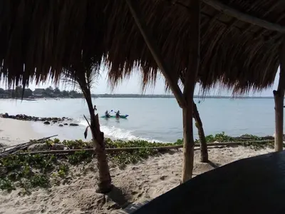 two people are in the water on a beach at Hostel Blue Sea Rincon del Mar in Rincón