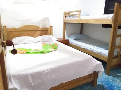 a bedroom with two bunk beds with white sheets at Hostel Blue Sea Rincon del Mar in Rincón