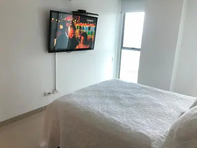 a bedroom with a tv hanging on the wall at Apartamentos en Morros Cartagena in Cartagena de Indias