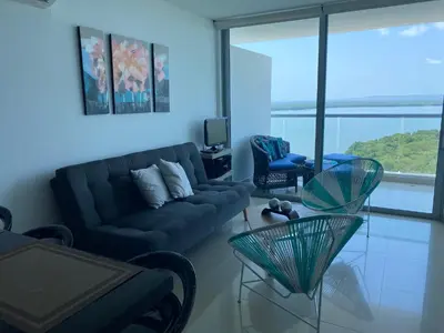 a living room with a black couch and a tv at Apartamentos en Morros Cartagena in Cartagena de Indias