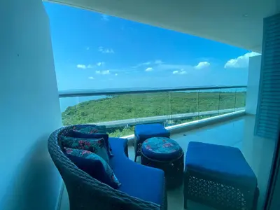 a balcony with chairs and a large window with a view at Apartamentos en Morros Cartagena in Cartagena de Indias