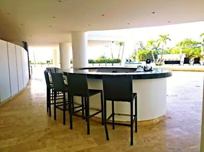 a bar with black bar stools in a building at Apartamentos en Morros Cartagena in Cartagena de Indias