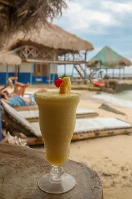 a drink sitting on a table on the beach at Isla Múcura Dahlandia in Isla Mucura