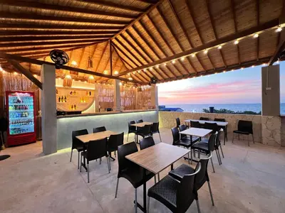 a restaurant with tables and chairs and a bar at Awa De Mar Hotel Tolu in Tolú