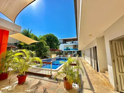 a swimming pool in a house with potted plants at Awa De Mar Hotel Tolu in Tolú
