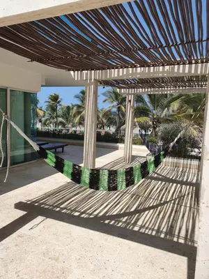 a hammock on the side of a building with palm trees at Apartamento Frente a la Playa Morros 922 in Cartagena de Indias